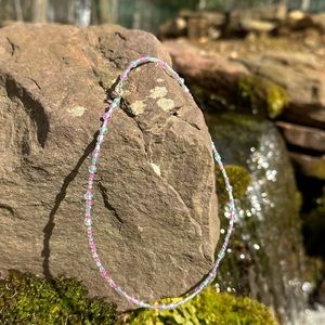 Delicate hand crafted 16” glass bead necklace with clasp. Shimmers in the sun